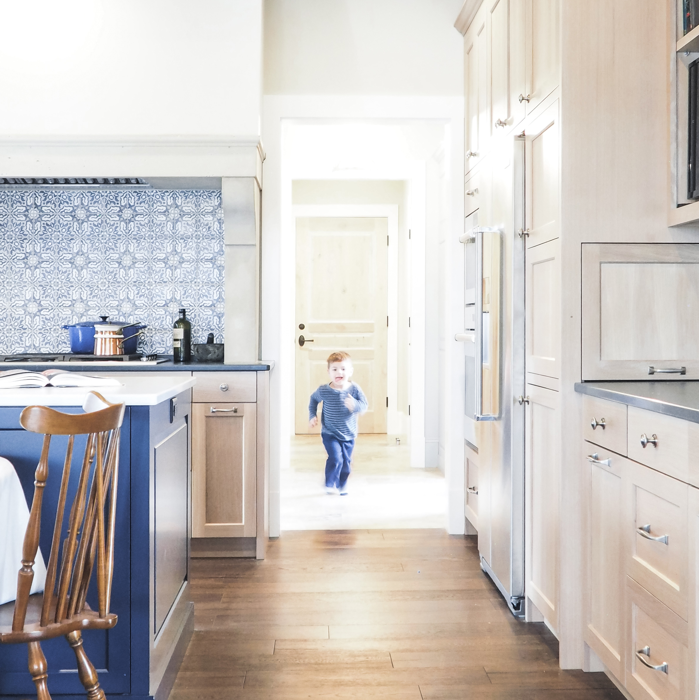 kitchen photograph with cast stone hood and blue tile backsplash